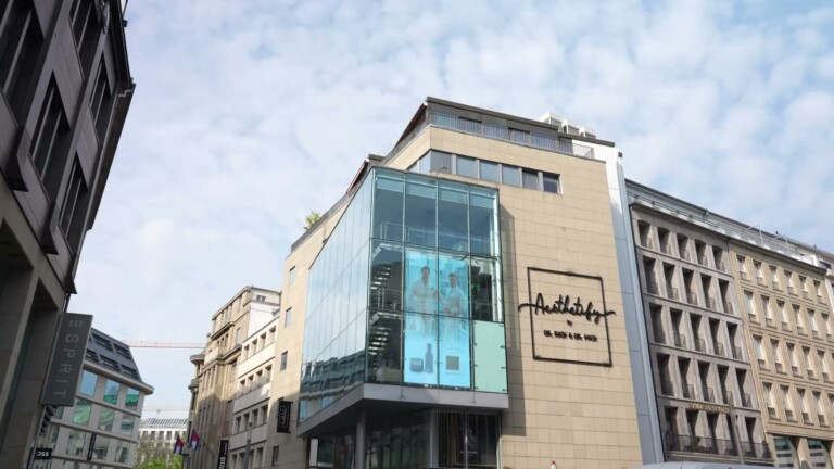 Aesthetify Düsseldorf – Moderne Glasfassade mit Aesthetify-Schriftzug in einer Innenstadtstraße